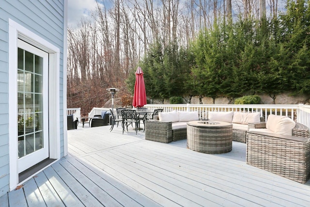 wooden terrace with an outdoor living space with a fire pit