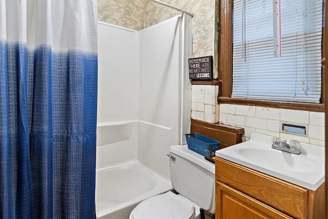 bathroom with backsplash, walk in shower, vanity, tile walls, and toilet