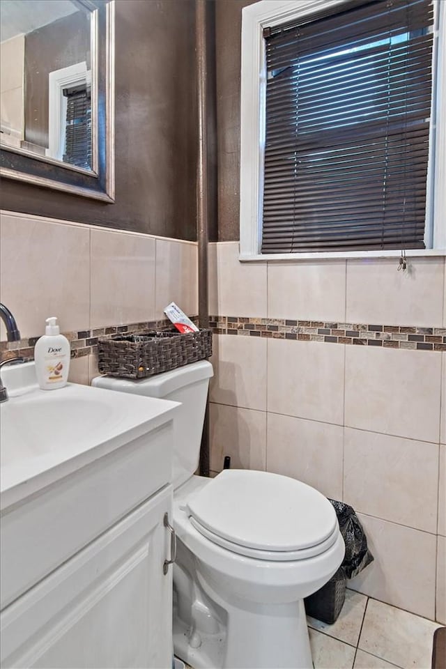 bathroom with tile patterned flooring, vanity, tile walls, and toilet