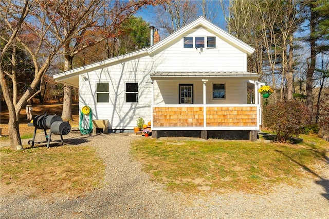 view of front of home with covered porch and a front lawn