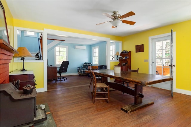 dining space with ceiling fan, a healthy amount of sunlight, dark hardwood / wood-style flooring, and a wall unit AC