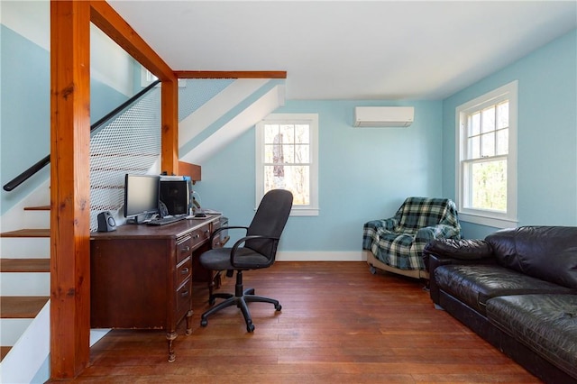 home office with dark hardwood / wood-style flooring, lofted ceiling, and a wall unit AC