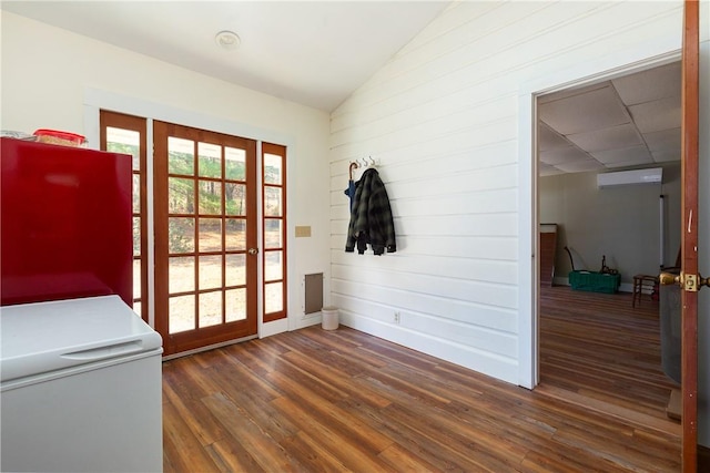 entryway featuring dark hardwood / wood-style floors, vaulted ceiling, and a wall unit AC