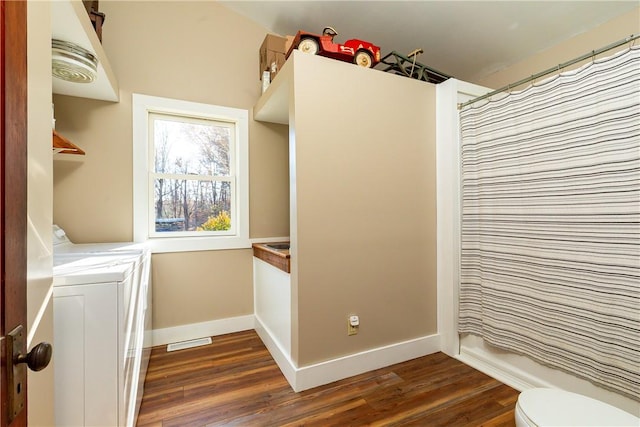 clothes washing area with washing machine and dryer and dark hardwood / wood-style floors