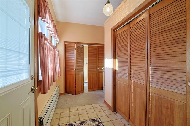 hallway with baseboard heating and light tile patterned floors