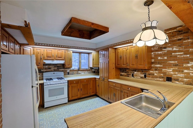 kitchen featuring backsplash, kitchen peninsula, sink, and white appliances