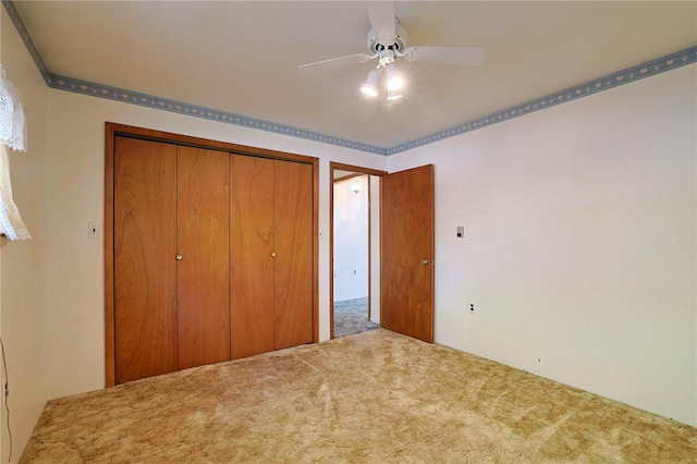 unfurnished bedroom with carpet floors, a closet, and ceiling fan