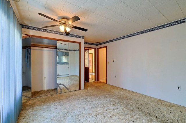 unfurnished bedroom with ceiling fan, a closet, and carpet floors