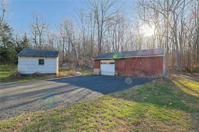 view of outdoor structure with a lawn and a garage