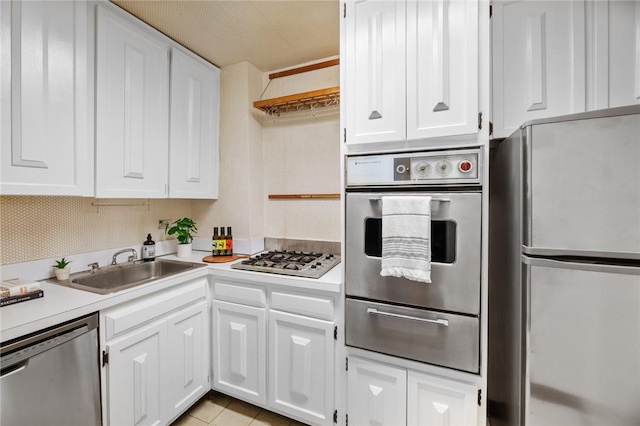 kitchen featuring white cabinetry, sink, light tile patterned floors, and stainless steel appliances