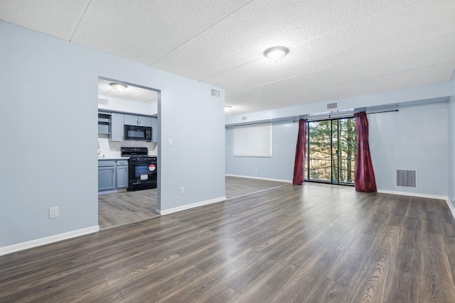 interior space with a barn door, dark hardwood / wood-style flooring, and a textured ceiling