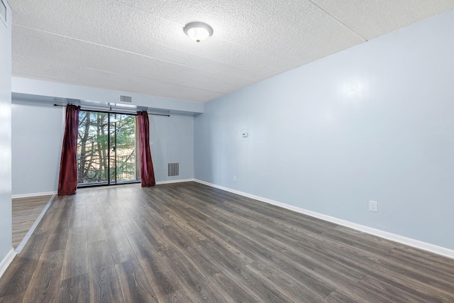 unfurnished room featuring a textured ceiling and dark hardwood / wood-style flooring