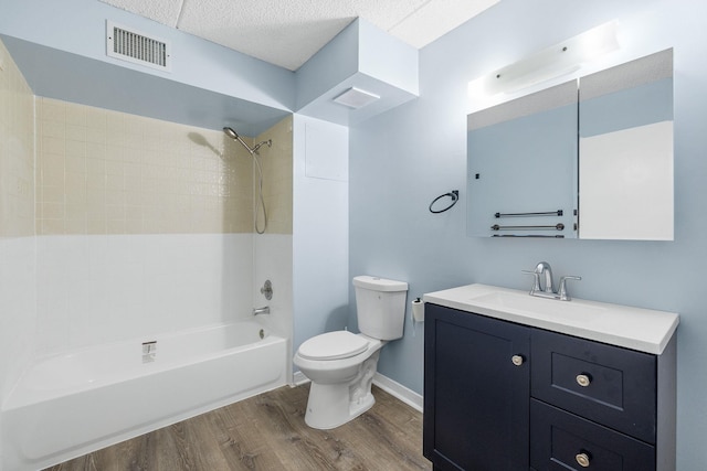 full bathroom with vanity, wood-type flooring, tiled shower / bath combo, and toilet