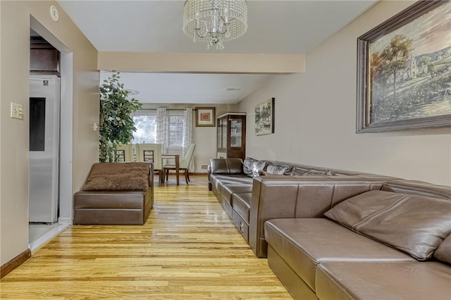 living room featuring a chandelier and light wood-type flooring