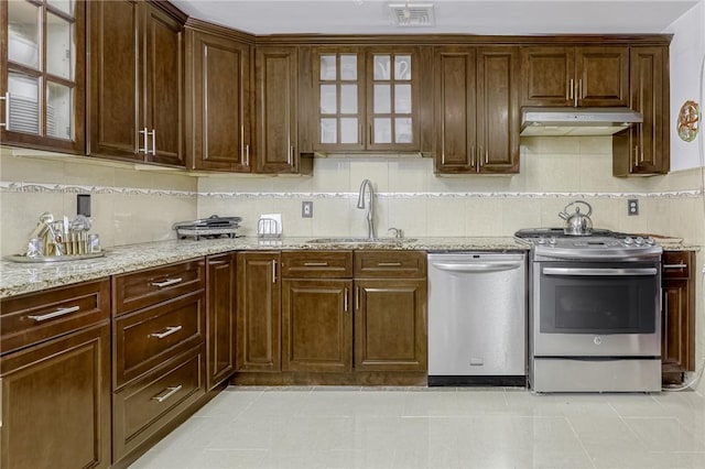 kitchen featuring backsplash, sink, light tile patterned floors, and stainless steel appliances