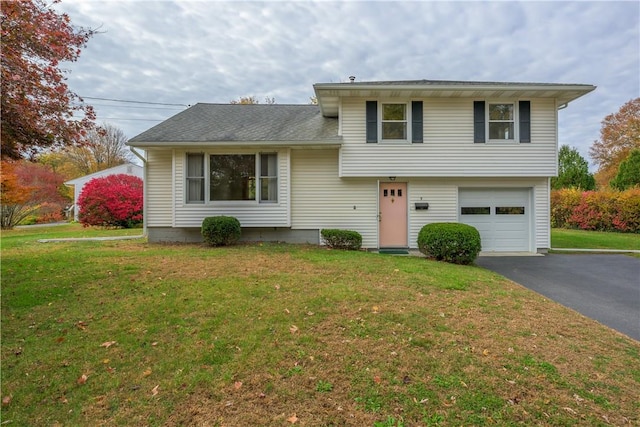 tri-level home with a garage and a front yard