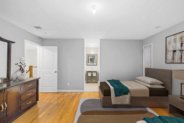 bedroom featuring light hardwood / wood-style floors and connected bathroom