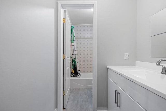 bathroom with hardwood / wood-style floors, vanity, and shower / tub combo