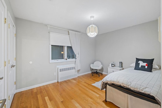 bedroom featuring radiator and light hardwood / wood-style flooring