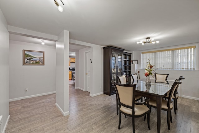 dining space with an inviting chandelier and light wood-type flooring