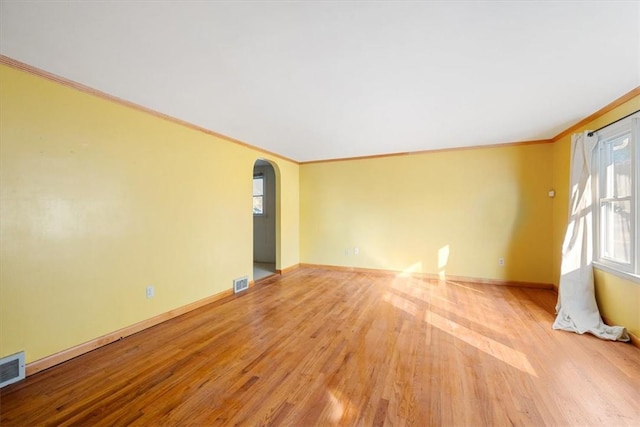 empty room featuring light hardwood / wood-style floors and ornamental molding