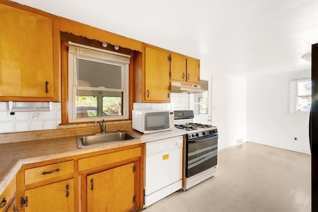 kitchen featuring backsplash, sink, and white appliances