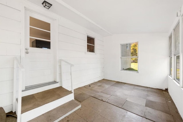 unfurnished sunroom featuring plenty of natural light and lofted ceiling