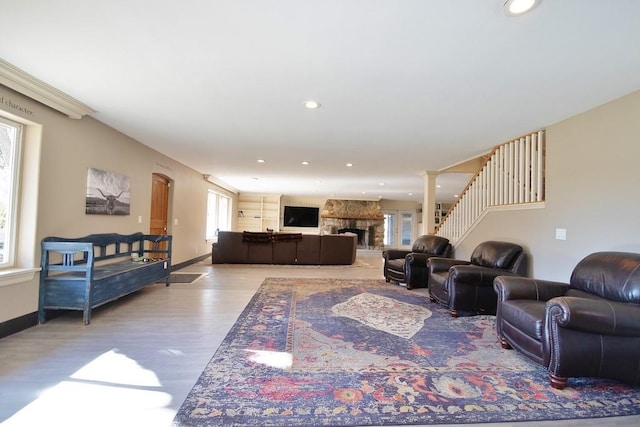 living room featuring ornate columns, a fireplace, and light hardwood / wood-style flooring