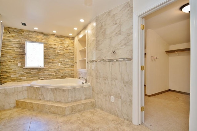 bathroom with tile patterned flooring, tiled bath, and built in features