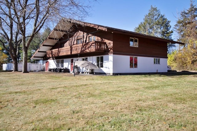 rear view of house with a lawn and a wooden deck