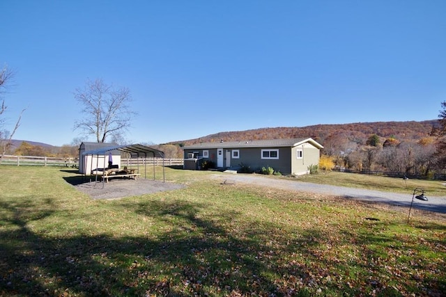 view of yard featuring a mountain view, an outbuilding, and a carport