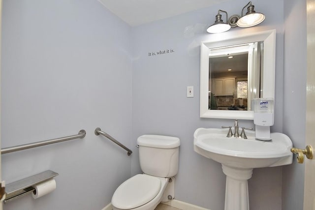 bathroom with toilet and baseboards