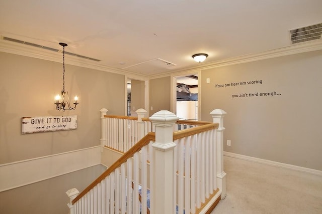 corridor featuring visible vents, carpet, a chandelier, ornamental molding, and an upstairs landing