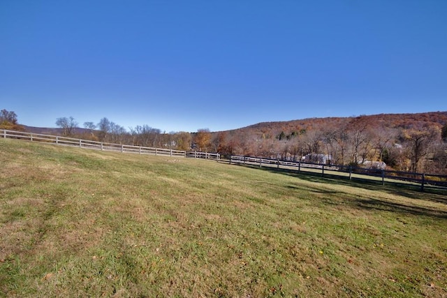 view of yard with a rural view and fence