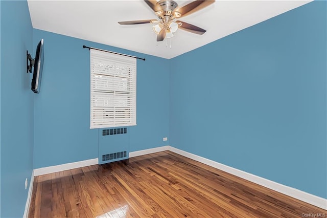 empty room featuring ceiling fan, wood finished floors, visible vents, and baseboards