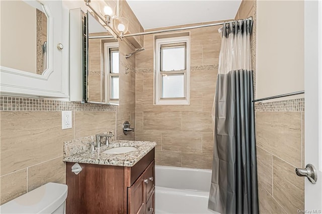 full bath featuring shower / tub combo, tile walls, toilet, and vanity