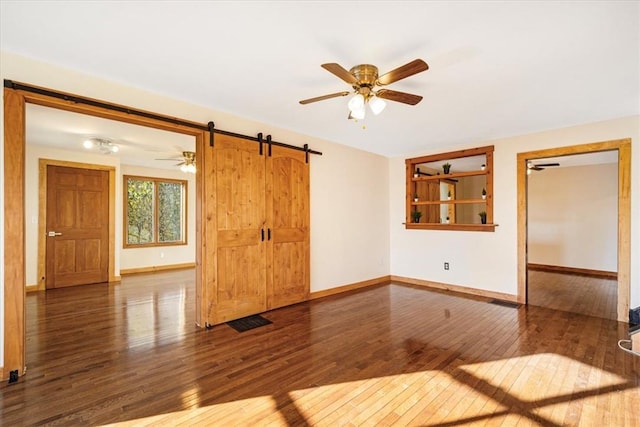 spare room featuring dark hardwood / wood-style floors and a barn door