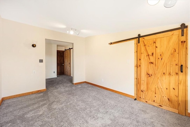 carpeted empty room featuring a barn door