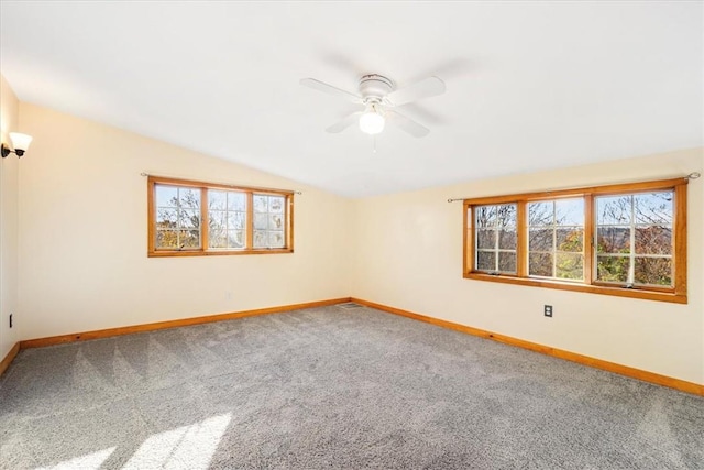 spare room with carpet flooring, vaulted ceiling, and ceiling fan