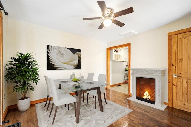 dining area featuring wood-type flooring and ceiling fan