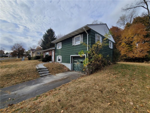 view of side of property featuring a lawn and a garage