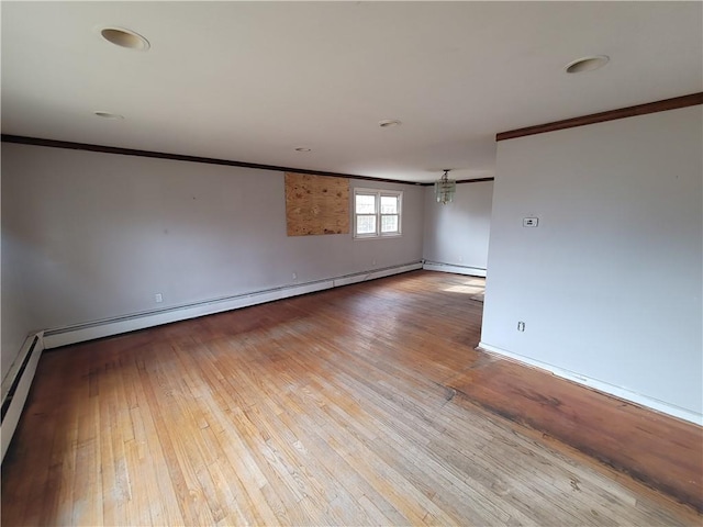 unfurnished room featuring crown molding, light hardwood / wood-style flooring, and a baseboard radiator