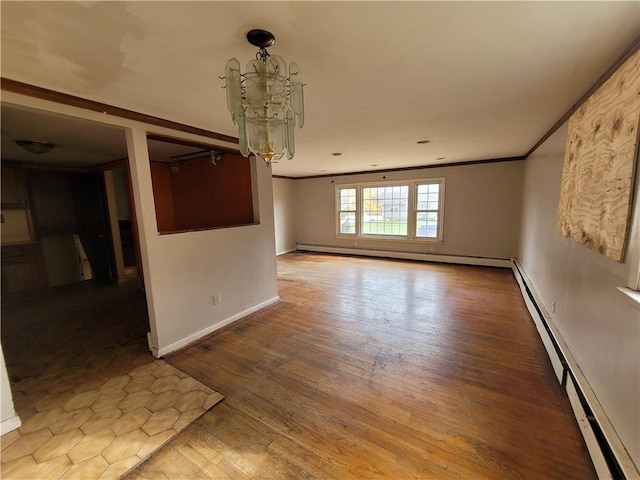 unfurnished room with crown molding, a baseboard heating unit, and hardwood / wood-style flooring