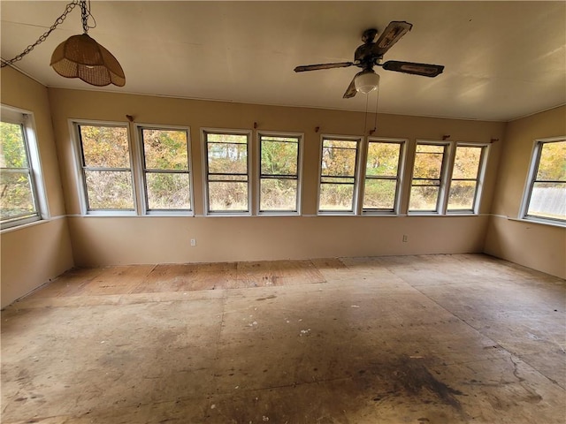 unfurnished sunroom with ceiling fan and plenty of natural light