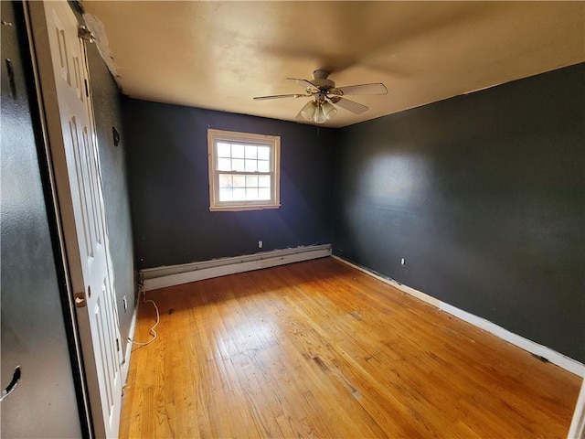 empty room featuring ceiling fan, light hardwood / wood-style flooring, and a baseboard radiator