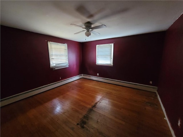 empty room with hardwood / wood-style flooring, ceiling fan, and a baseboard heating unit