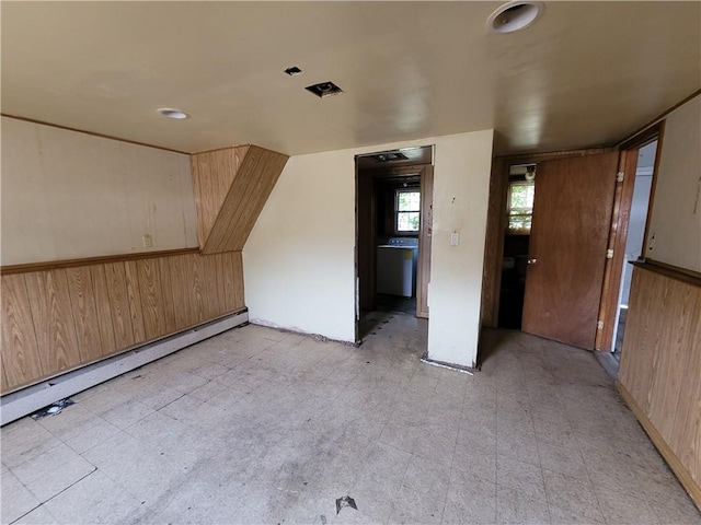 additional living space featuring baseboard heating and wooden walls