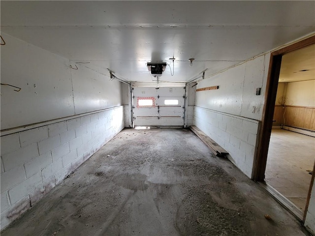 garage featuring a garage door opener and a baseboard heating unit