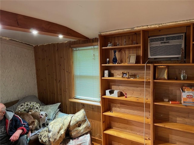 interior space featuring a wall mounted air conditioner, vaulted ceiling, and wood walls