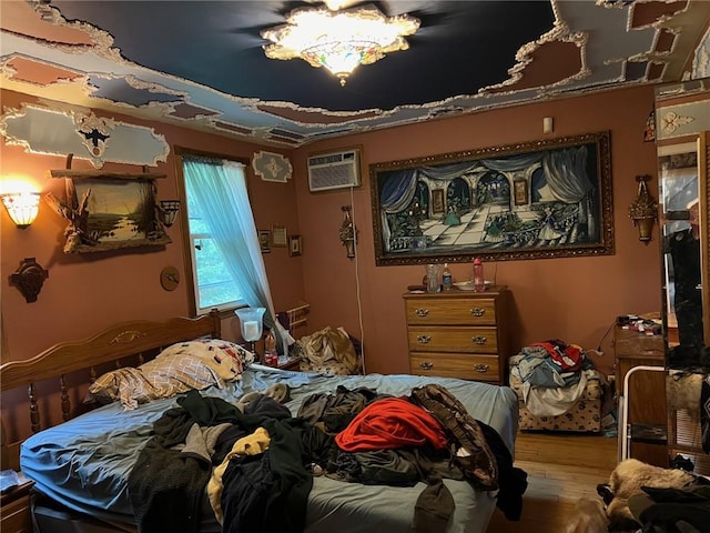 bedroom featuring a wall mounted air conditioner and hardwood / wood-style flooring